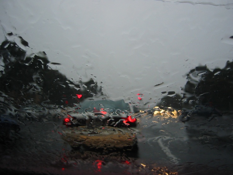Car lights seen through a rainy windscreen