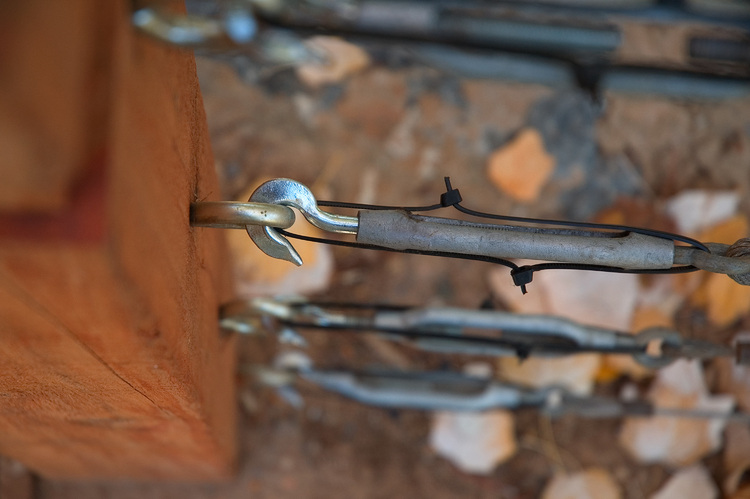 The end of a wire, hooked and tensioned onto a wooden post