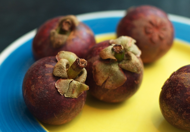 Several Mangosteen fruit, on a plate