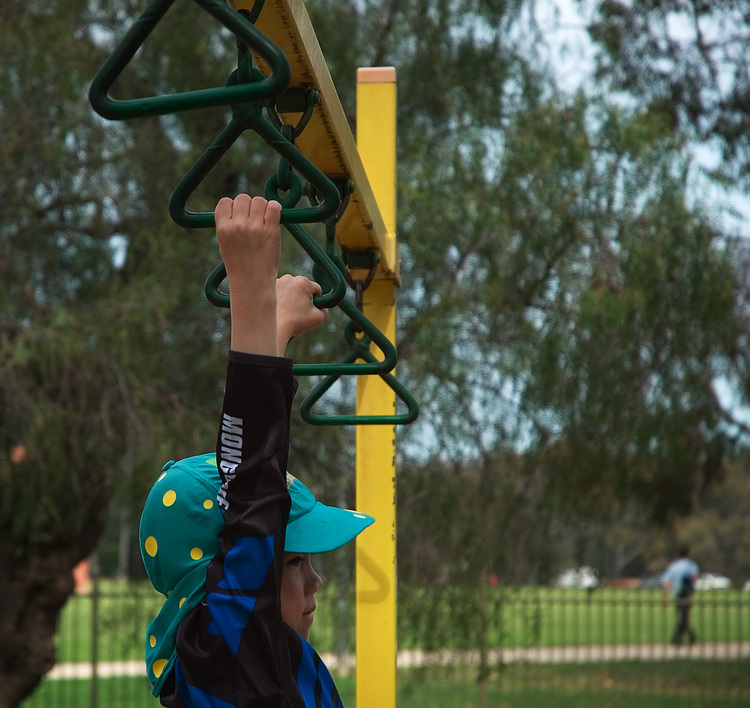 Michael hanging from playground equipment