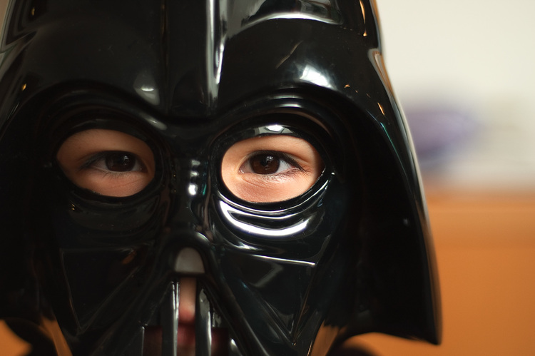 Closeup of Michael's eyes seen through a Darth Vader mask