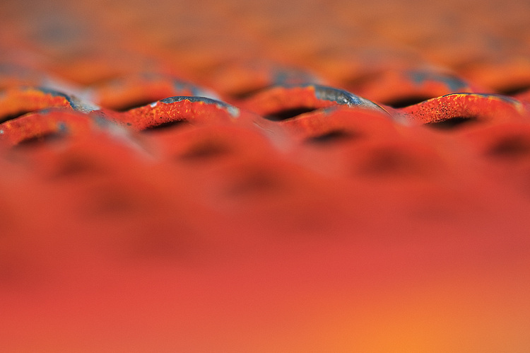 Closeup of an orange-painted metal grille