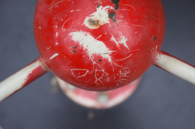 Scratched red paint on the top dome of a piece of playground equipment