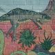 A dinosaur mural on a brick wall