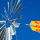 A steel windmill, against a blue sky