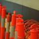 Orange safety cones, lined up next to a wall