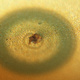 Closeup of a CD with a hole burnt into the metalized layer