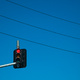 An overhead traffic light, surrounded by power lines