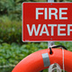 A life buoy, below a sign reading 'fire water'